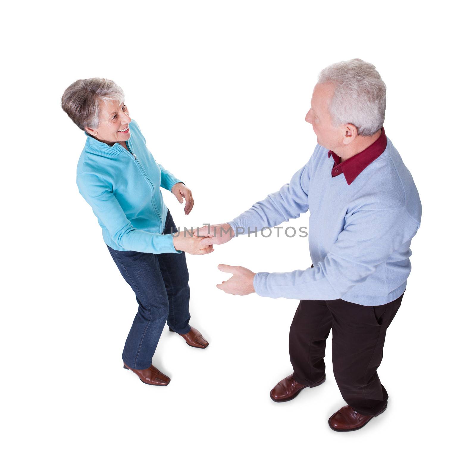 Portrait Of Senior Couple Dancing On White Background