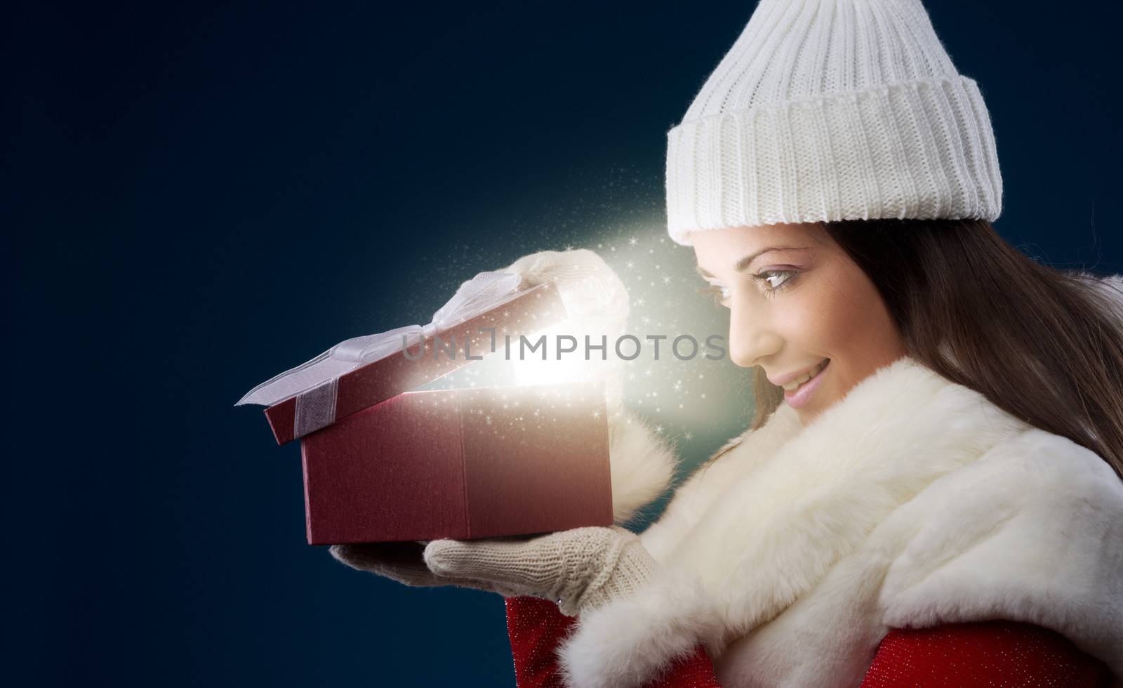 Happy young woman opening Christmas presents, copy space