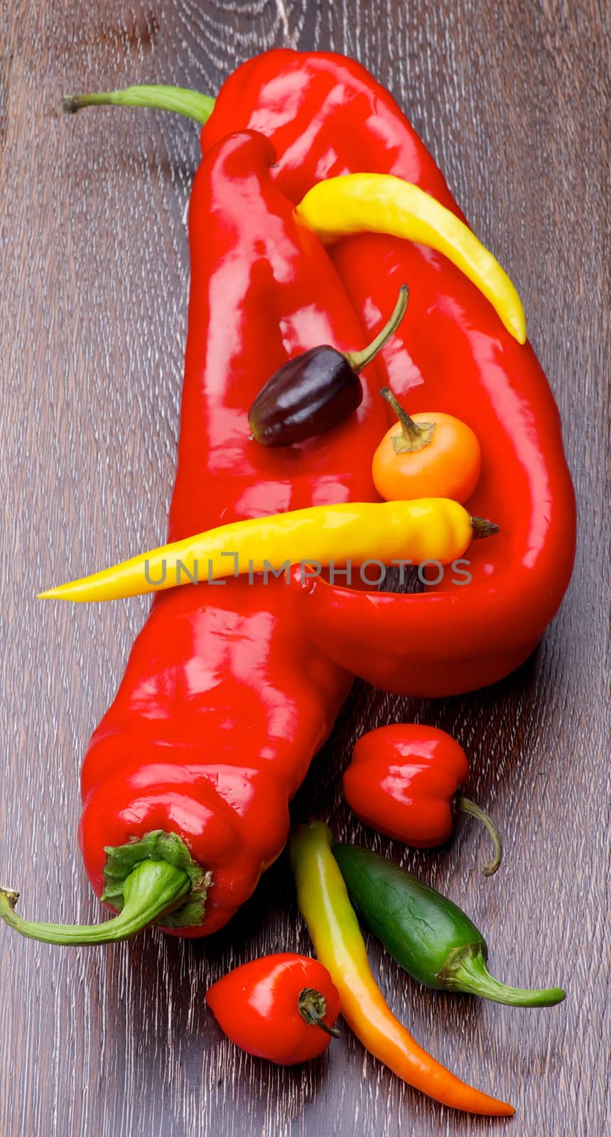 Arrangement of Various Ripe Ramiro, Chili and Jalapeno Peppers closeup on Wooden background