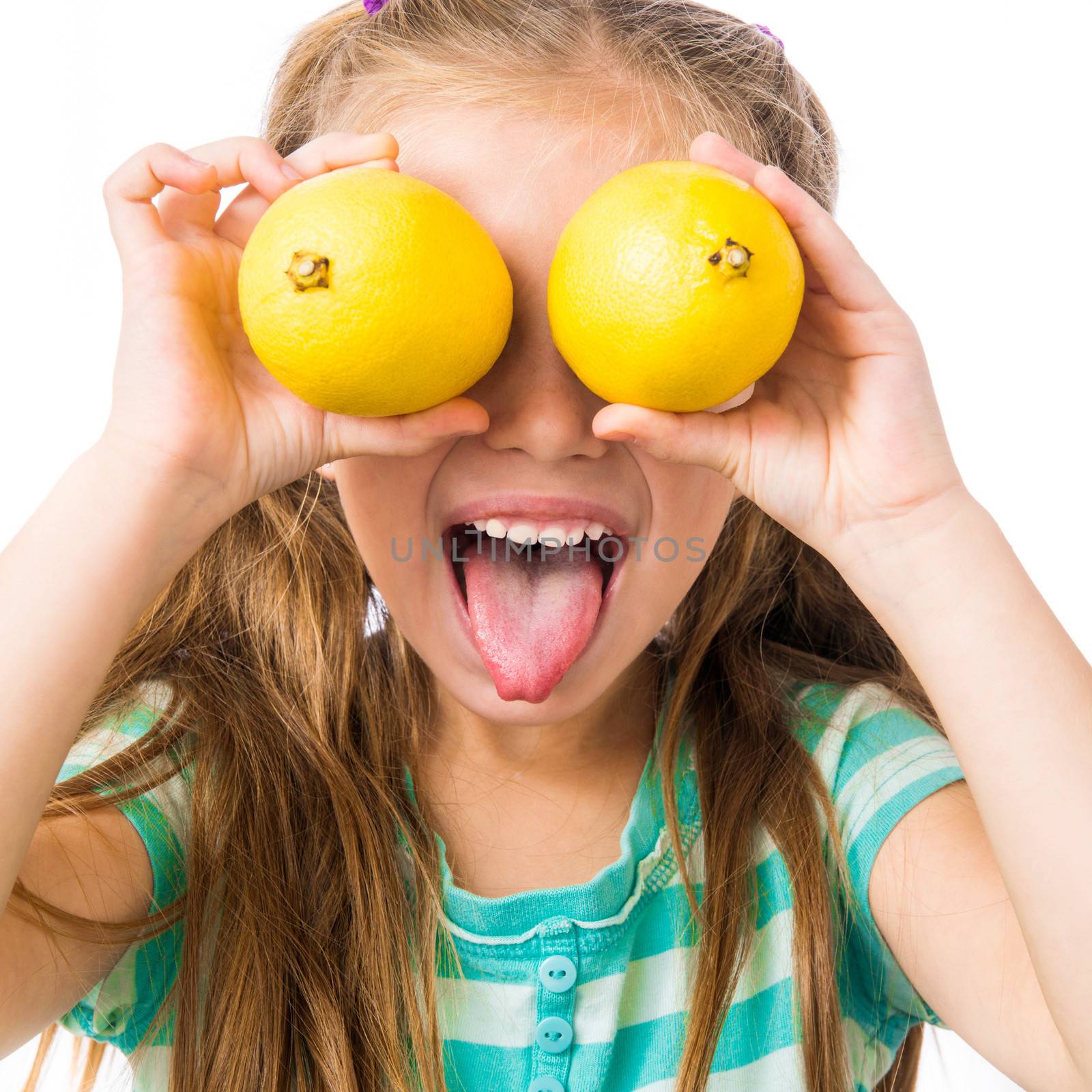 little girl with two lemons shows tongue isolated on white background