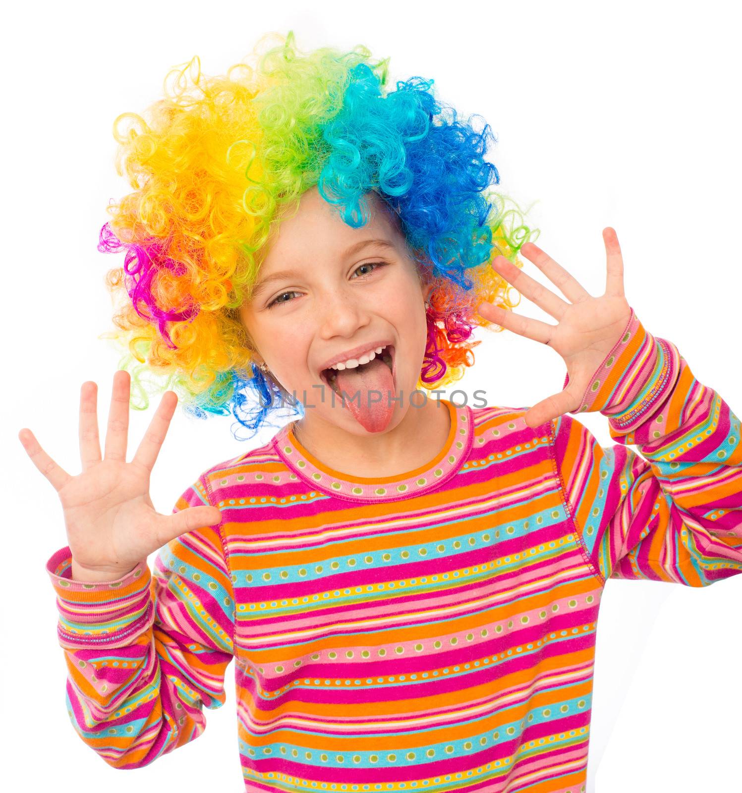 smiling little girl shows tongue and hands in clown wig isolated on white background