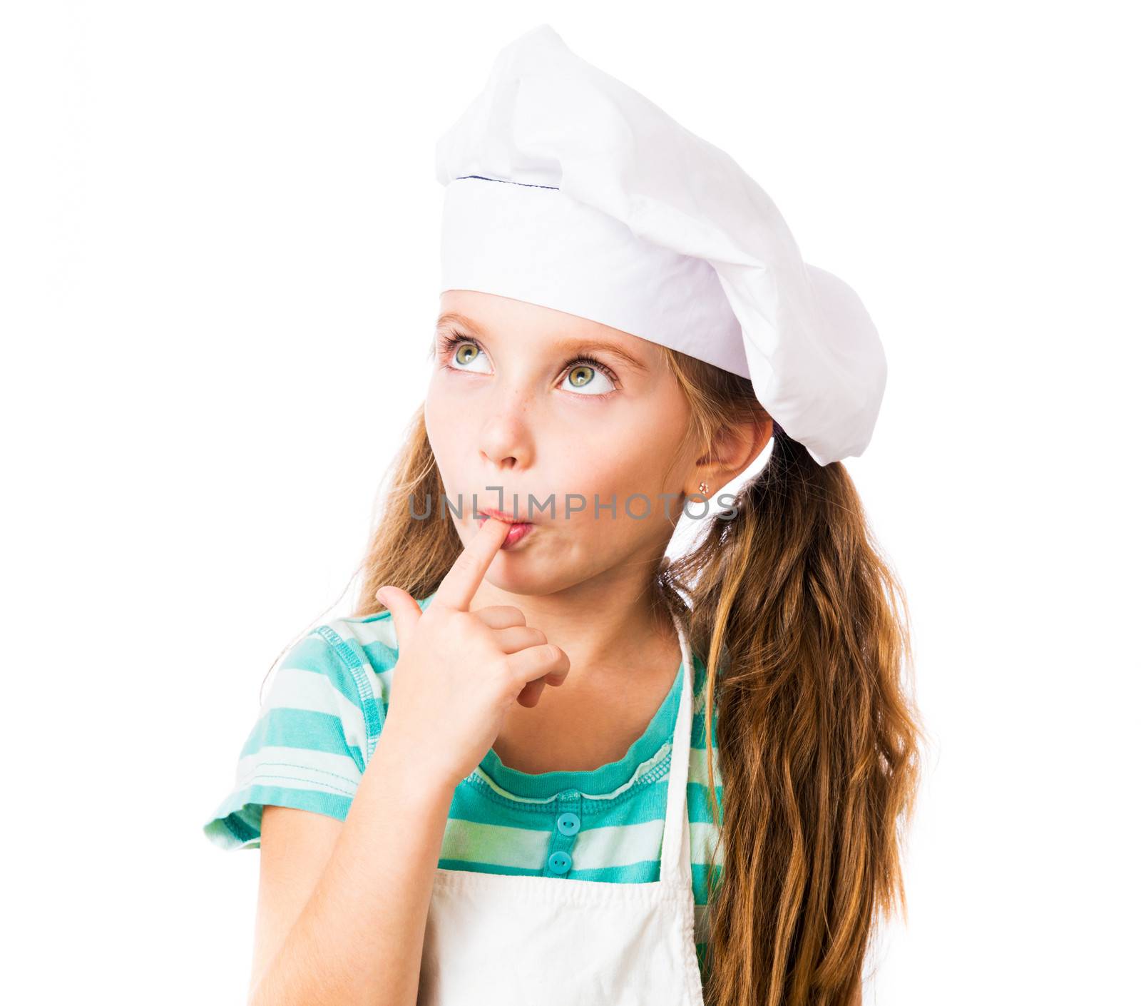 little girl in chef hat licks a finger on white background