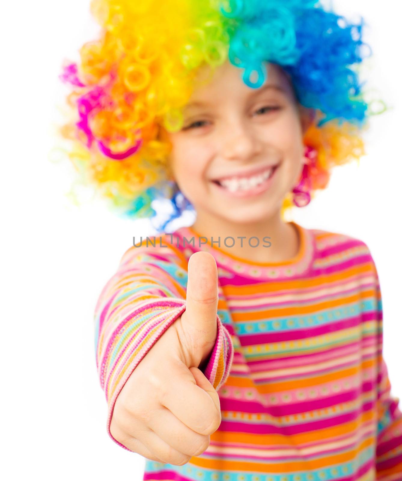 smiling little girl in clown wig with thumbs up isolated on white background