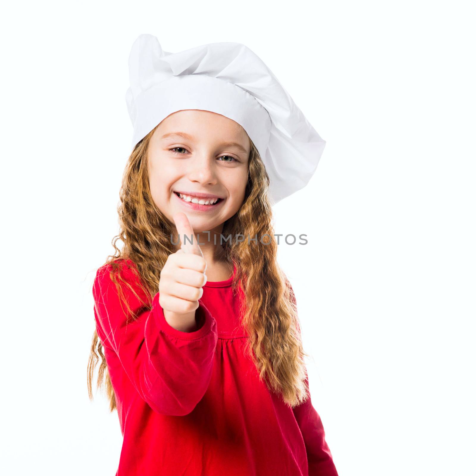 smiling little girl in chef hat with thumb up on white background