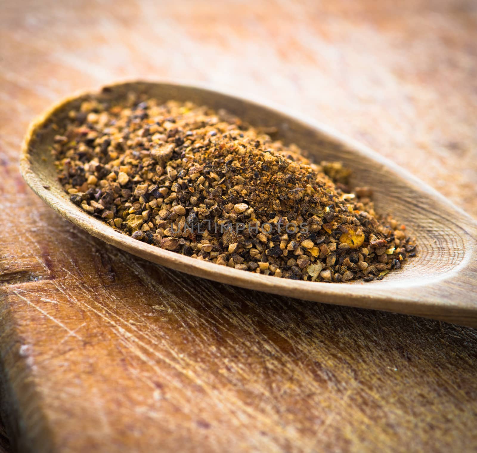 spices in a wooden spoon on cutting board