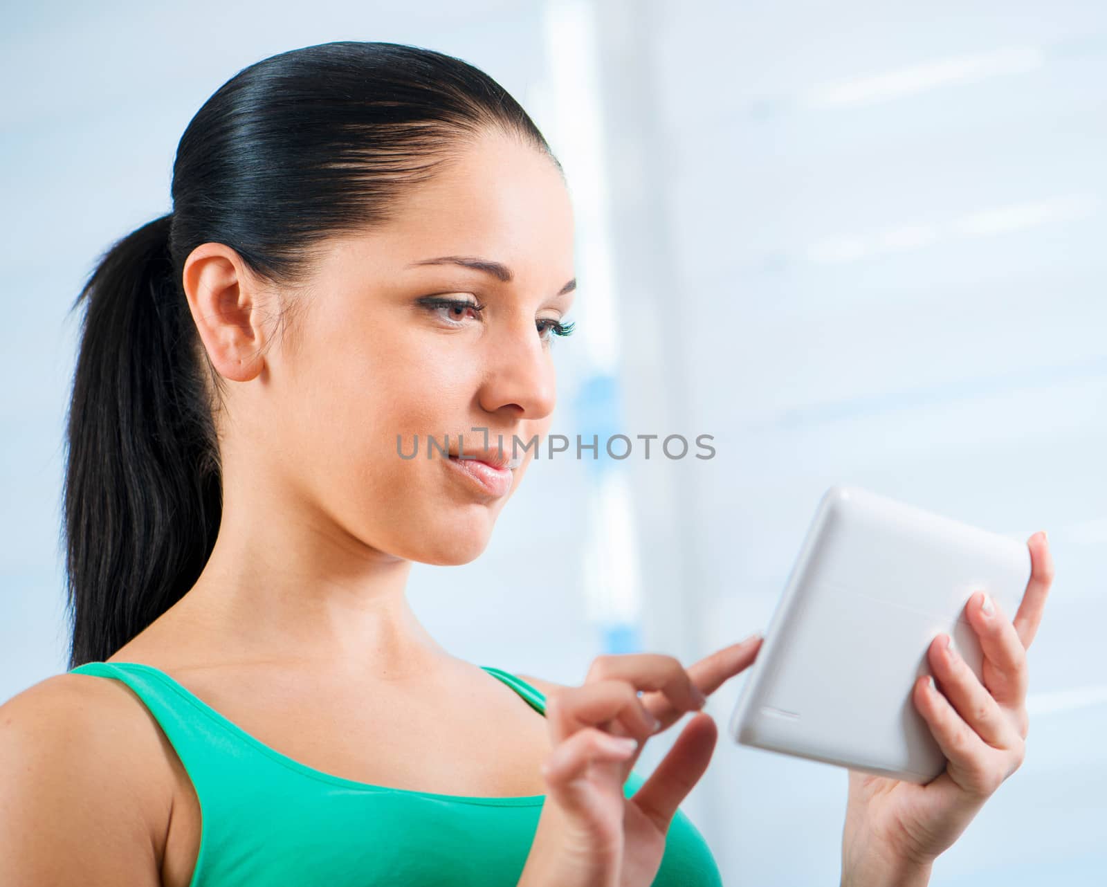 young smiling brunette woman working on white touch tablet
