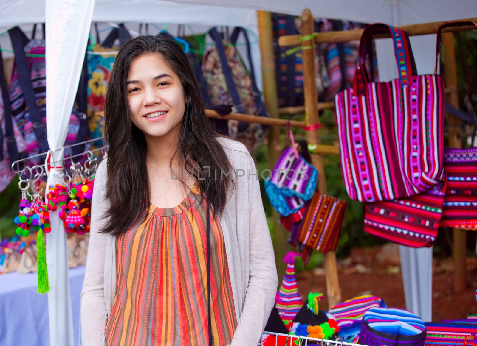 Biracial teen girl shopping at outdoor bazaar market in Thailand