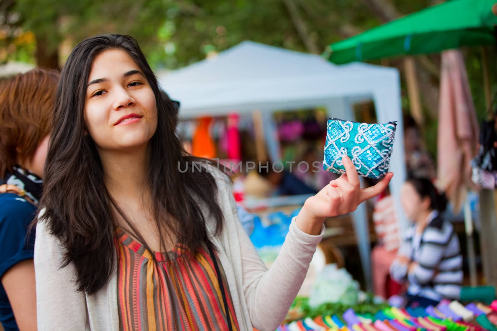 Biracial teen girl shopping at outdoor bazaar market in Thailand