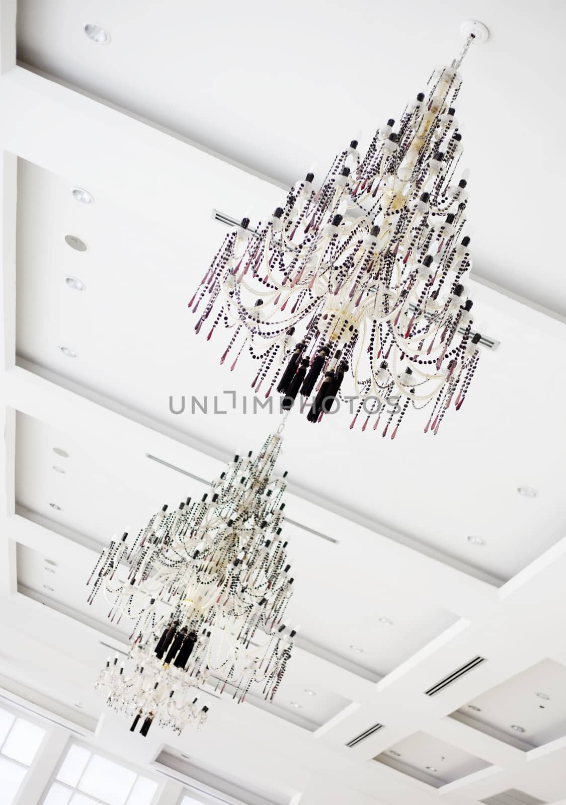 Two crystal chandeliers hanging on white ceiling by jarenwicklund
