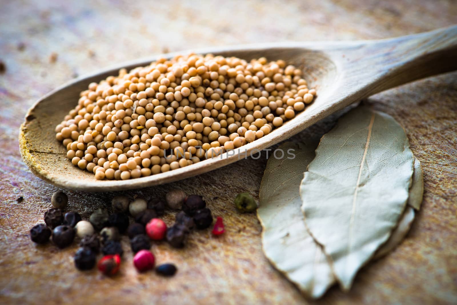 spices in a wooden spoon with laurel leaves on cutting board