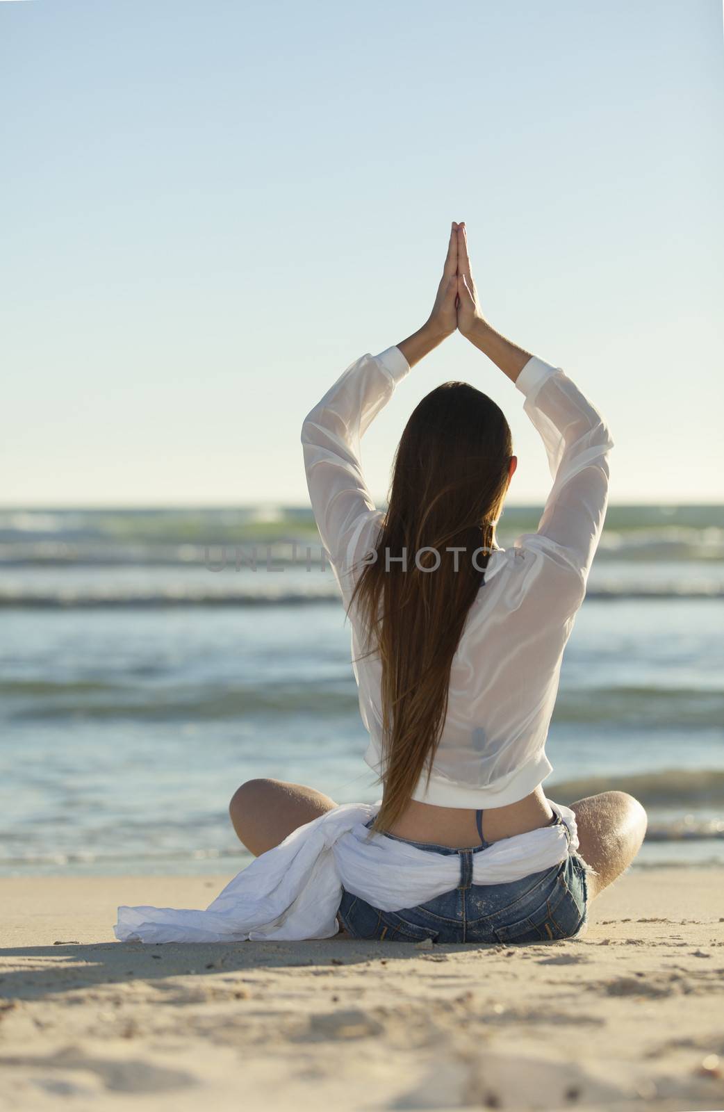 woman doing yoga on the beach by bernjuer