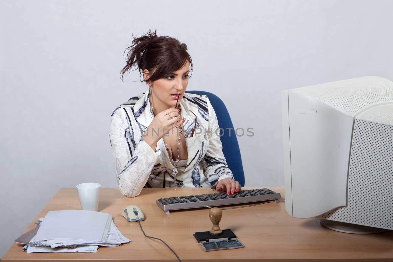 Young female office worker is concerned to work on computer