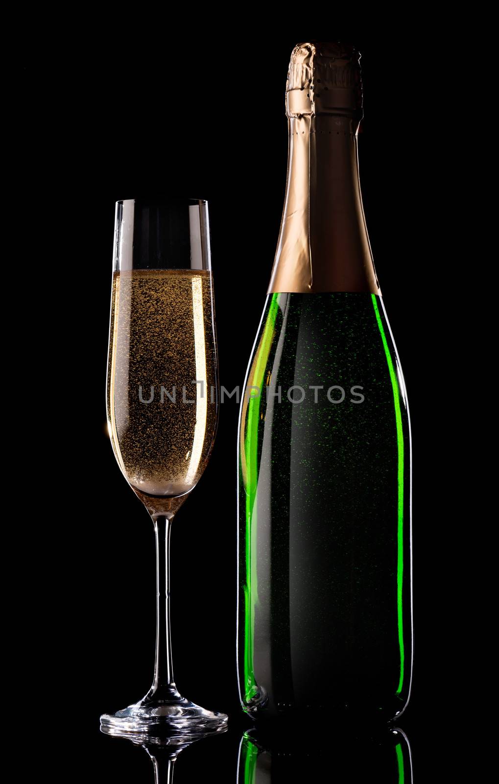 Glass and bottle of champagne on black background