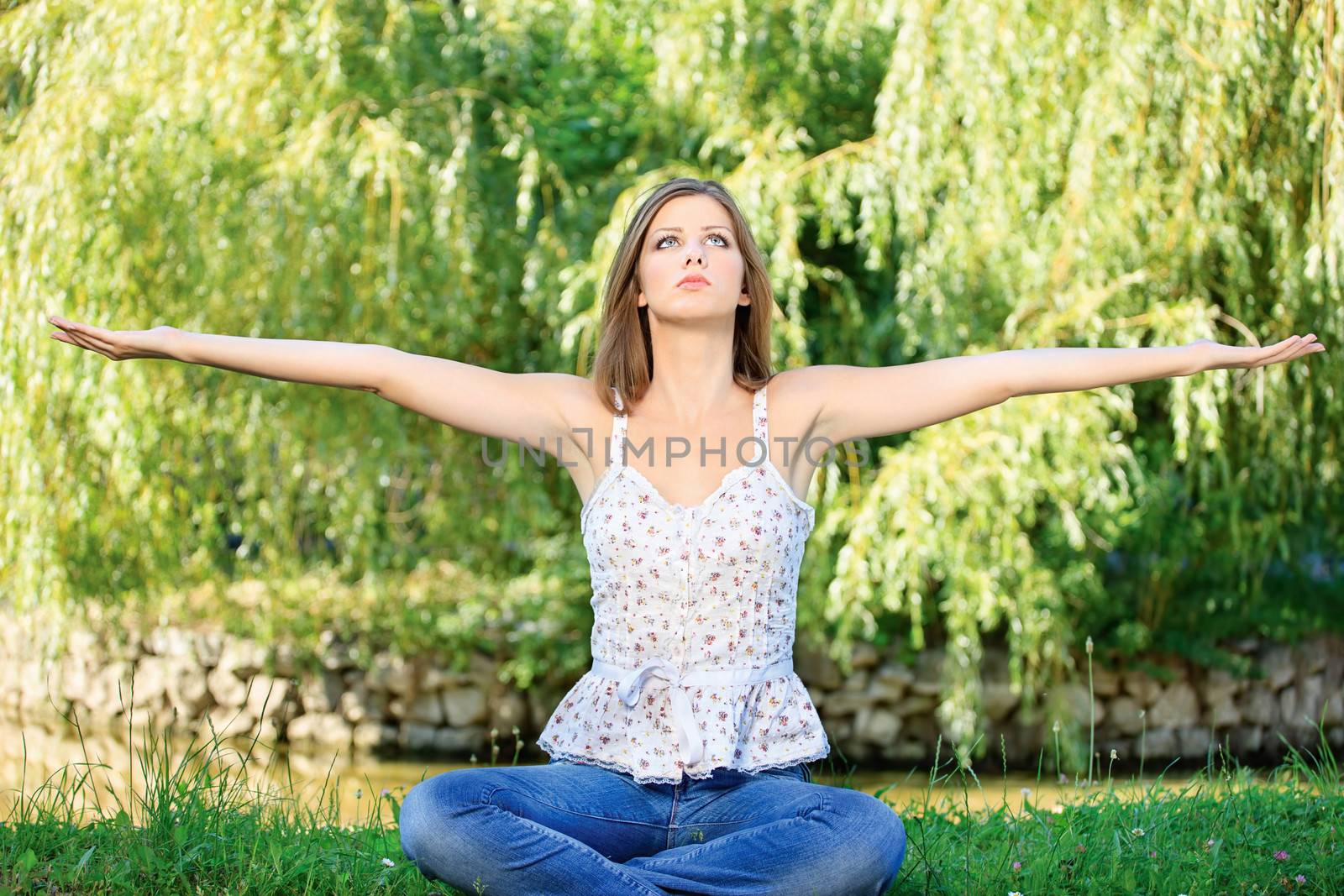 Young woman in lotus pose at the meditation outdoor