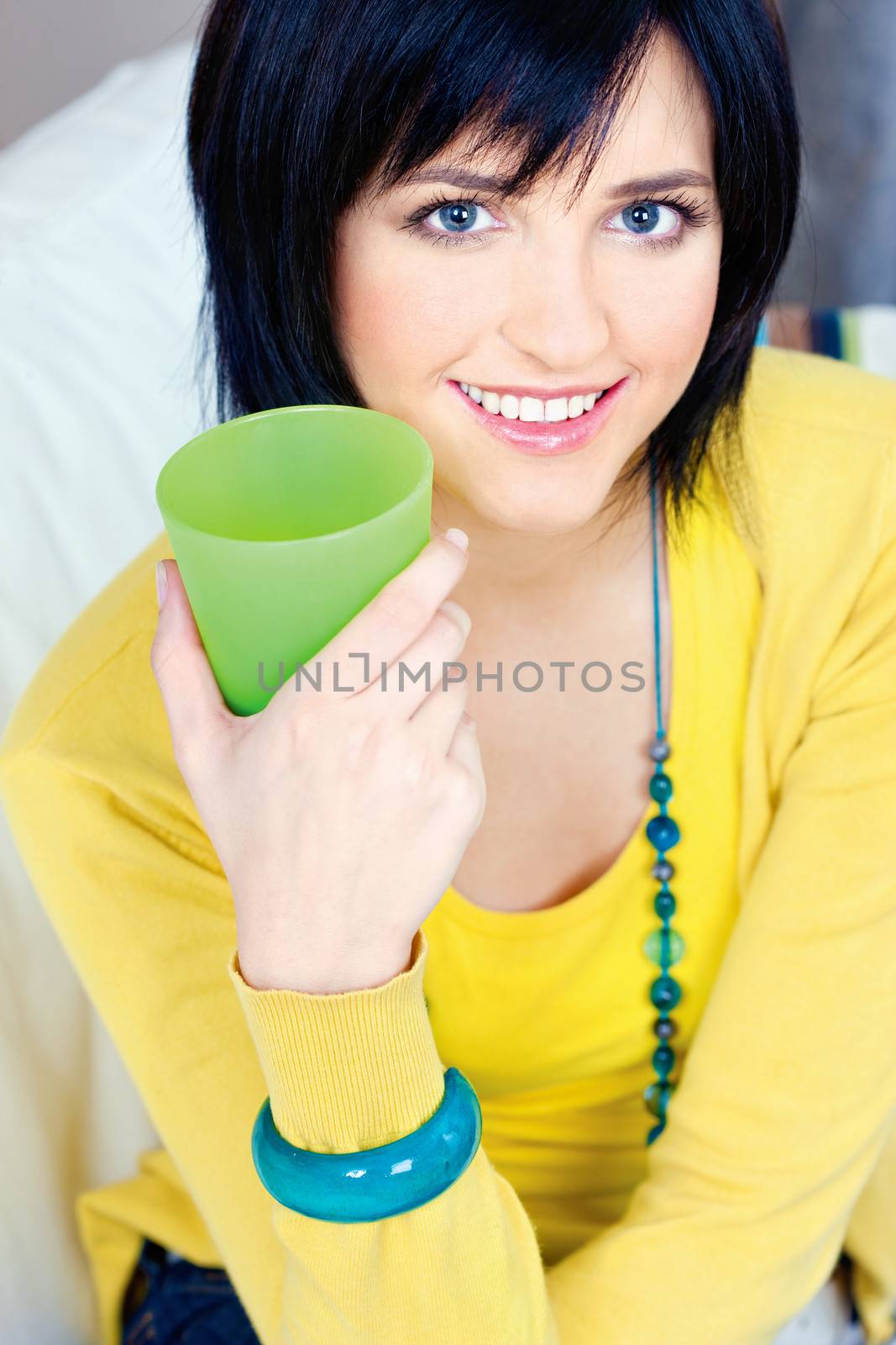 Pretty young woman with drink at home