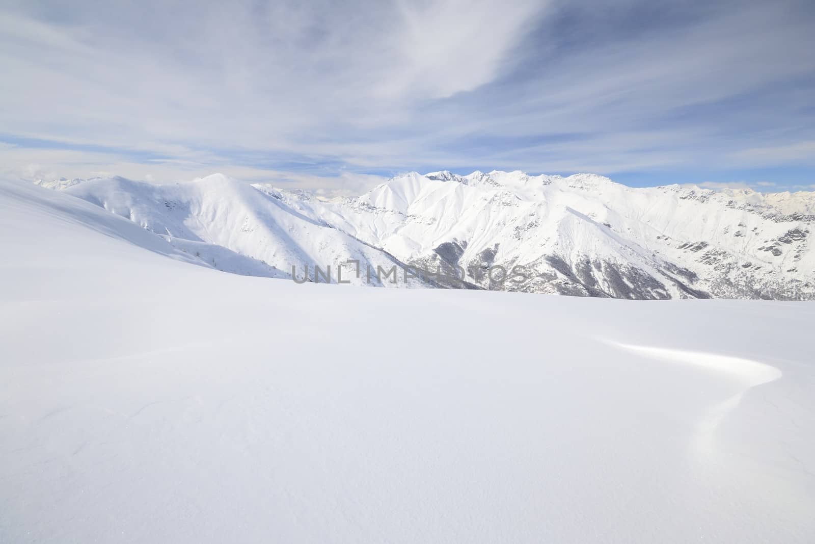 Candid off-piste ski slope in scenic background of high mountain peak