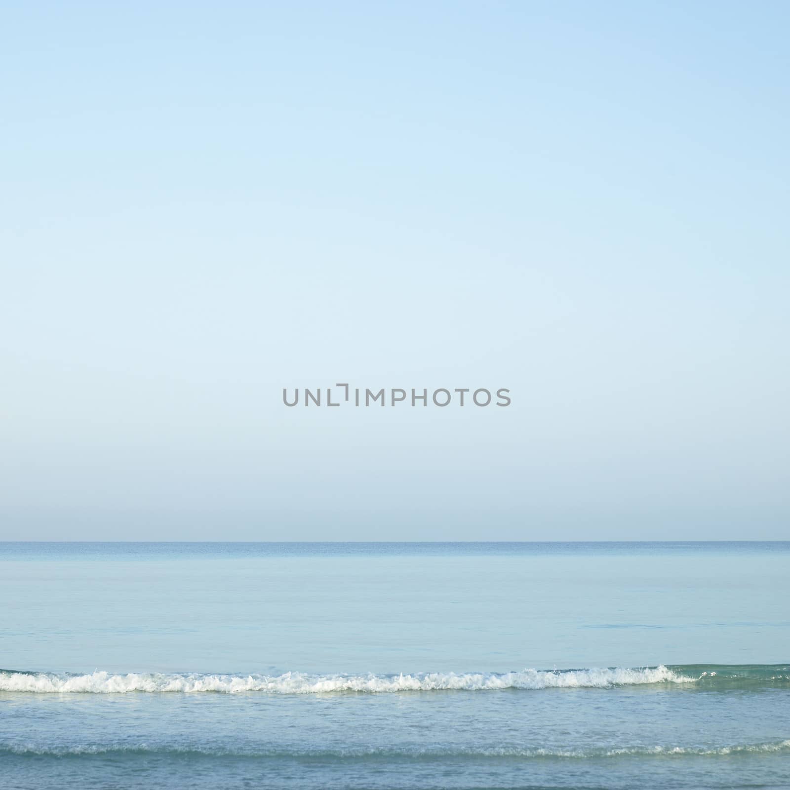 Beautiful turquoise wavy ocean with blue sky