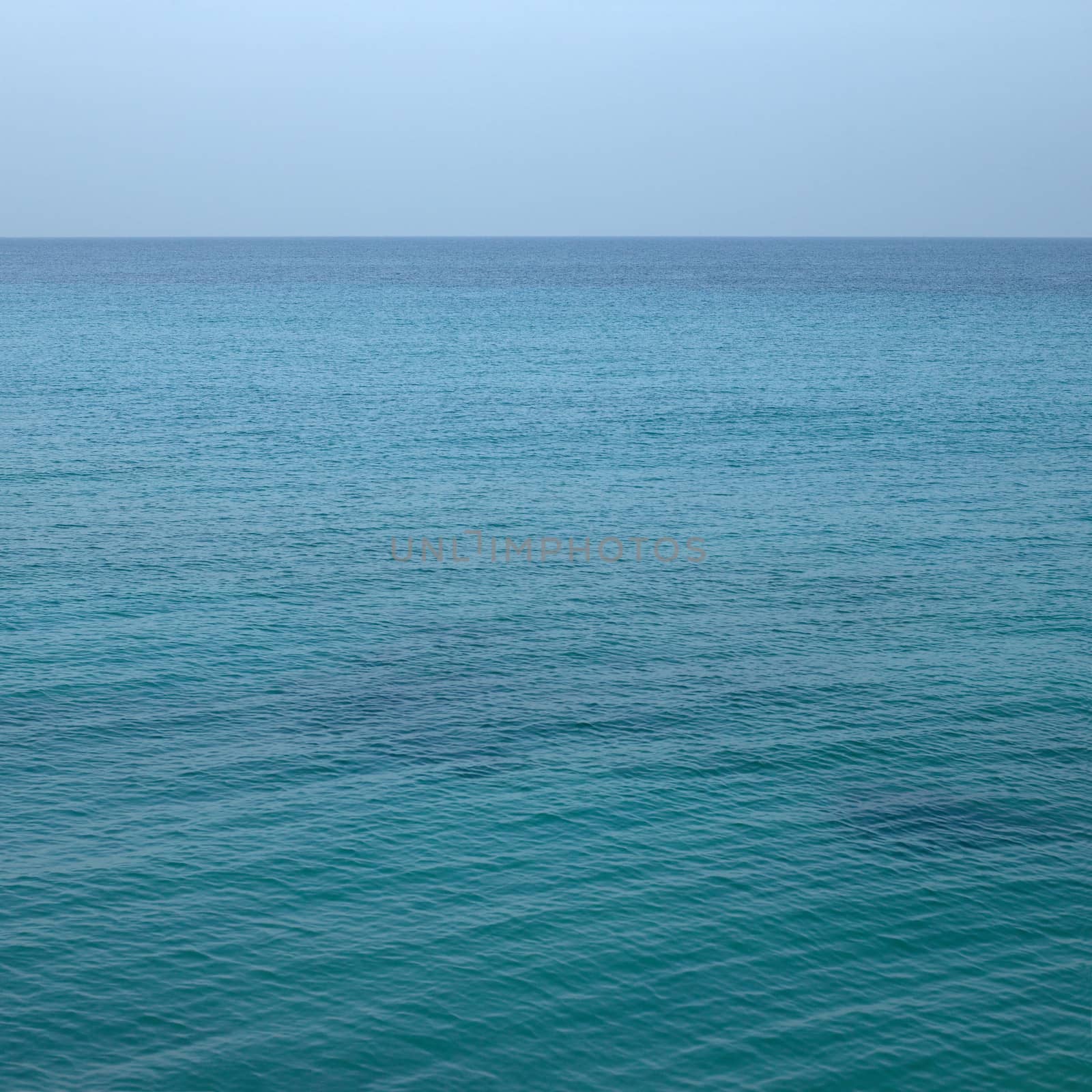 Beautiful turquoise wavy ocean with blue sky