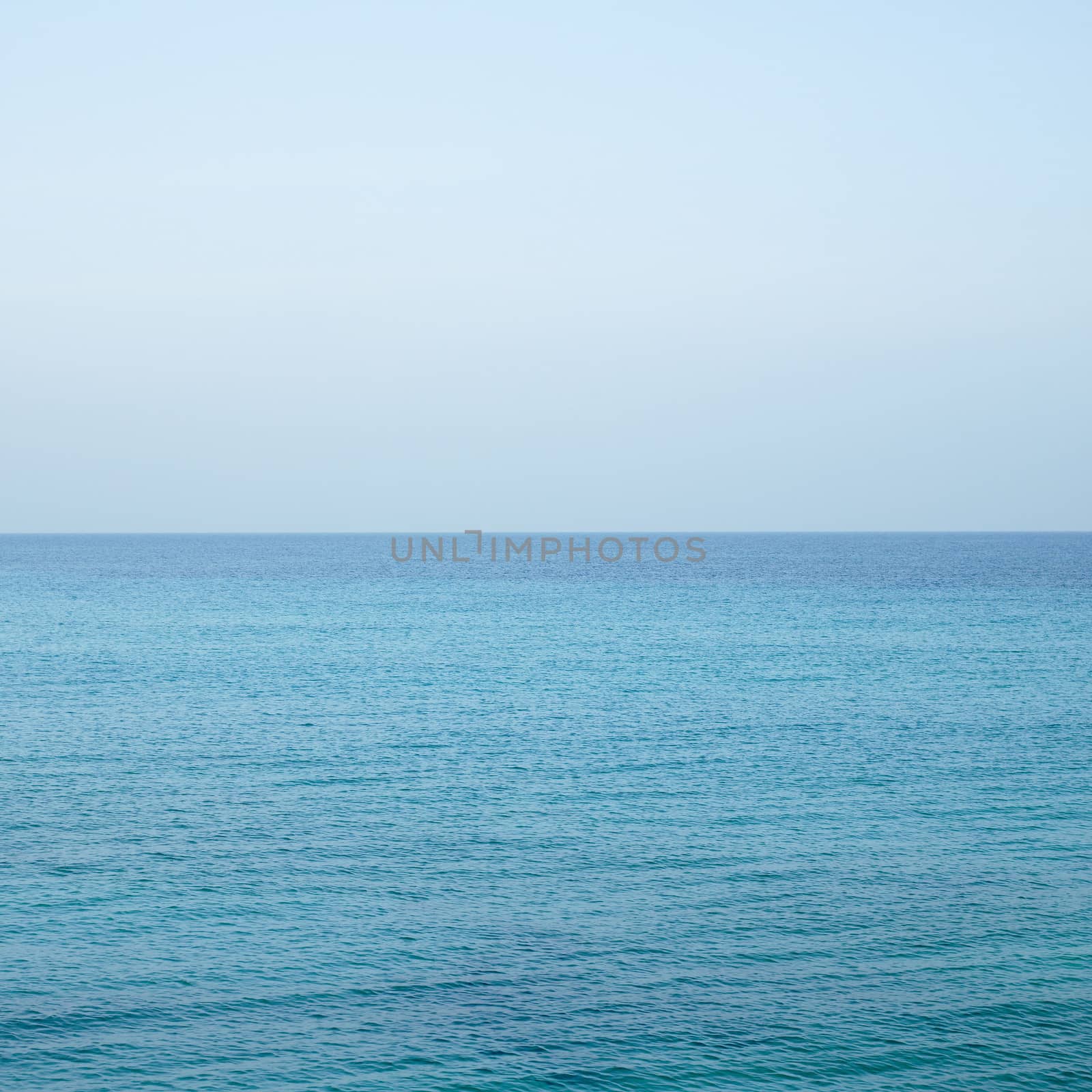 Beautiful turquoise wavy ocean with blue sky