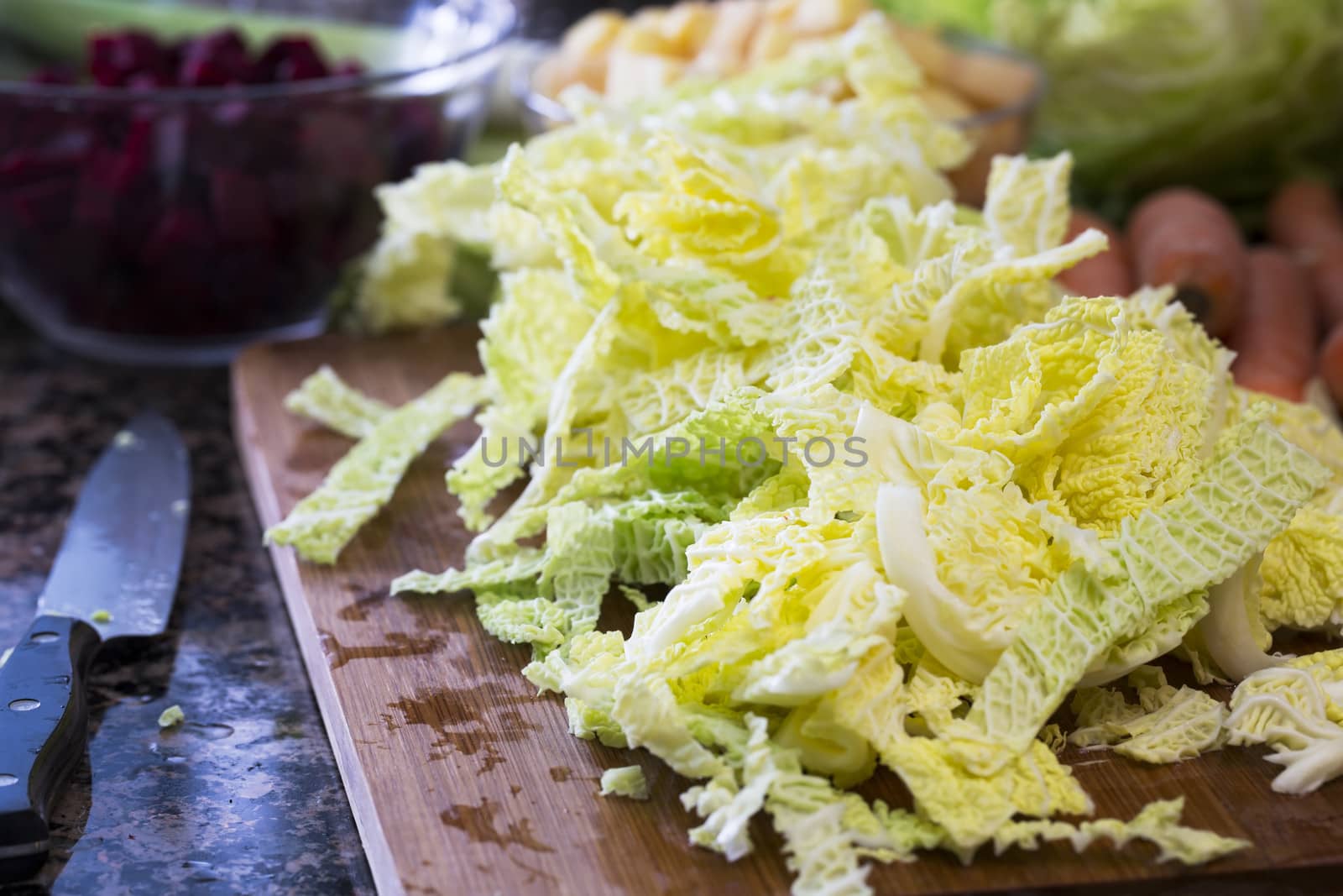 Chopped savoy cabbage on cutting board with knife