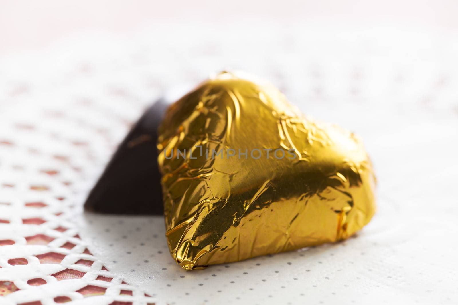 Two hearts, one wrapped in gold foil, one hidden.
