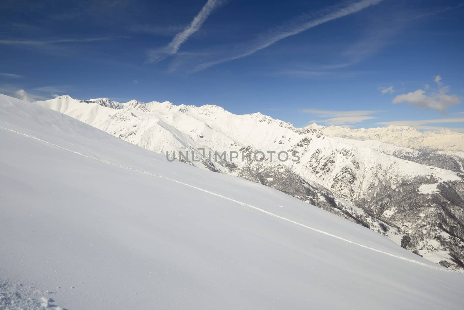 Candid off-piste ski slope in scenic background of high mountain peak