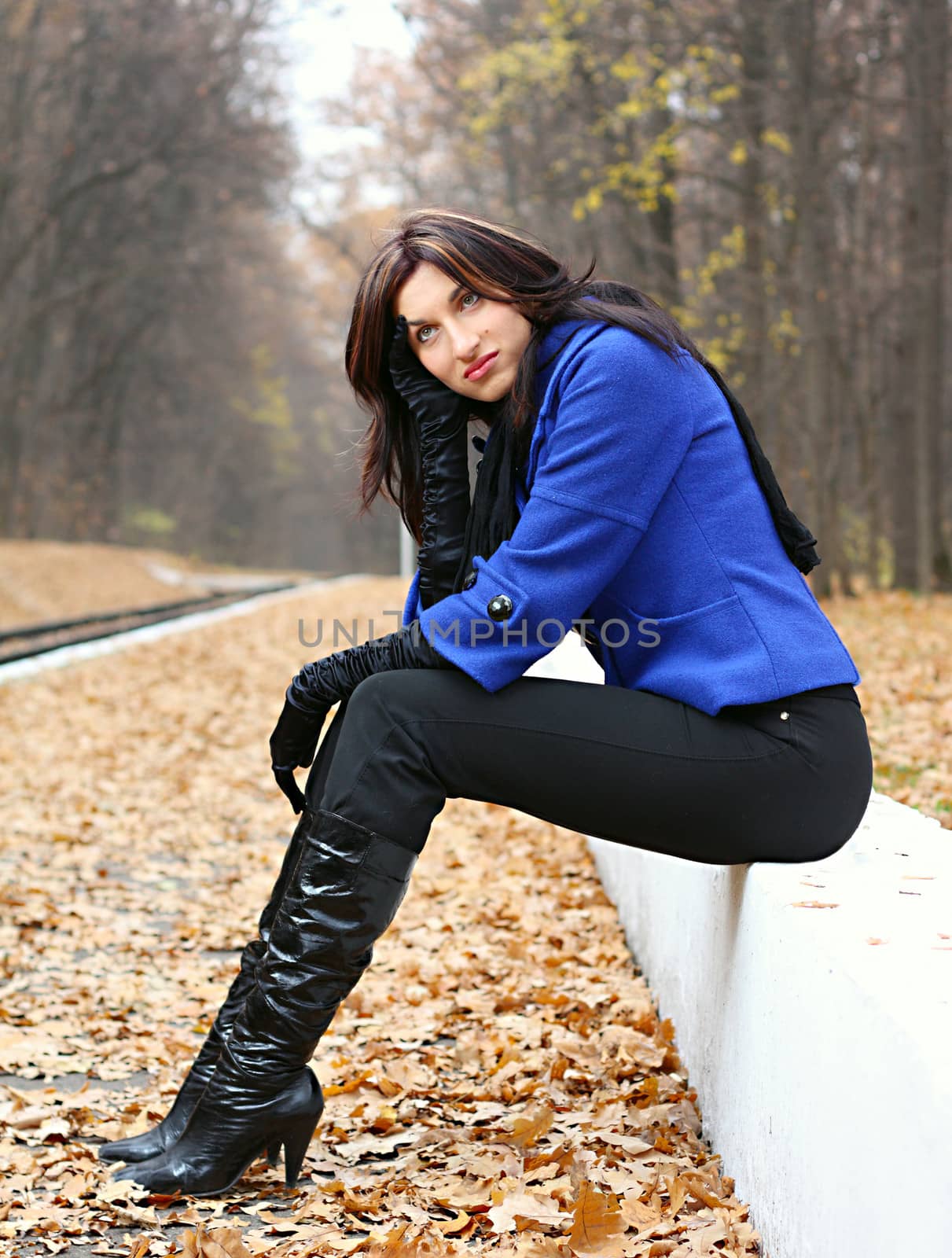 Young woman sitting in the autumn park
