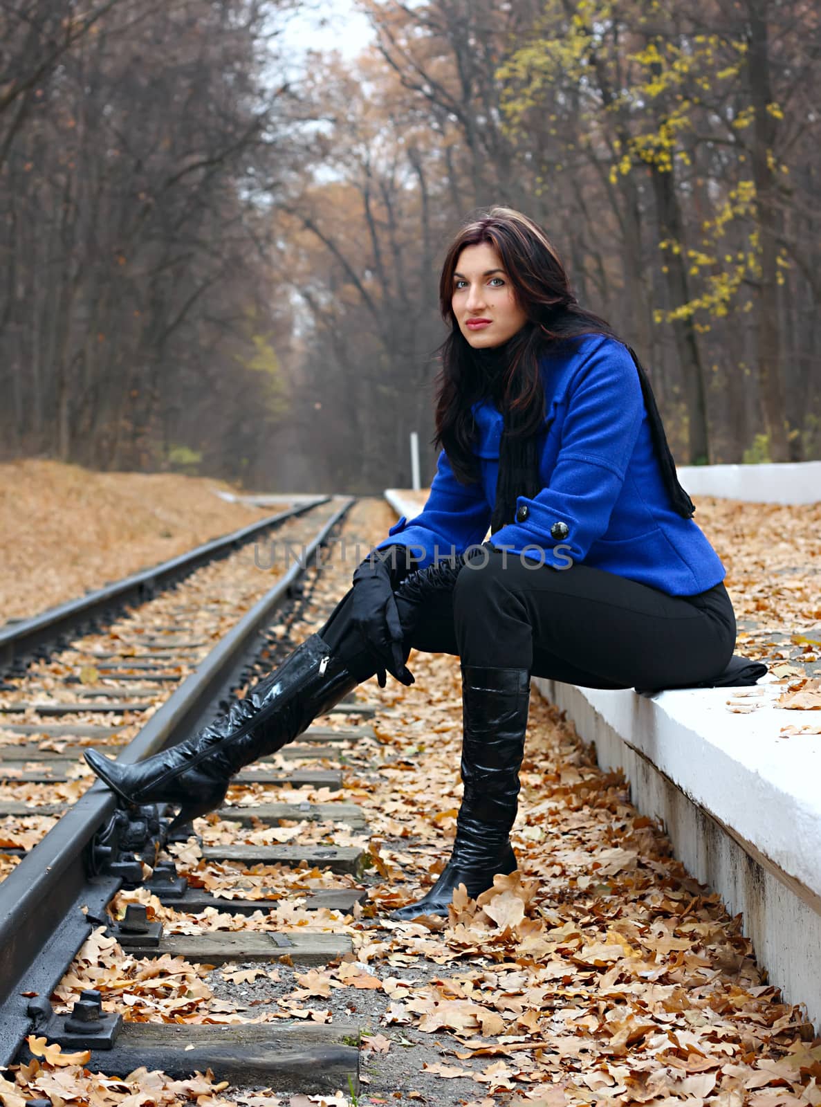 Young woman near the rails in the autumn forest