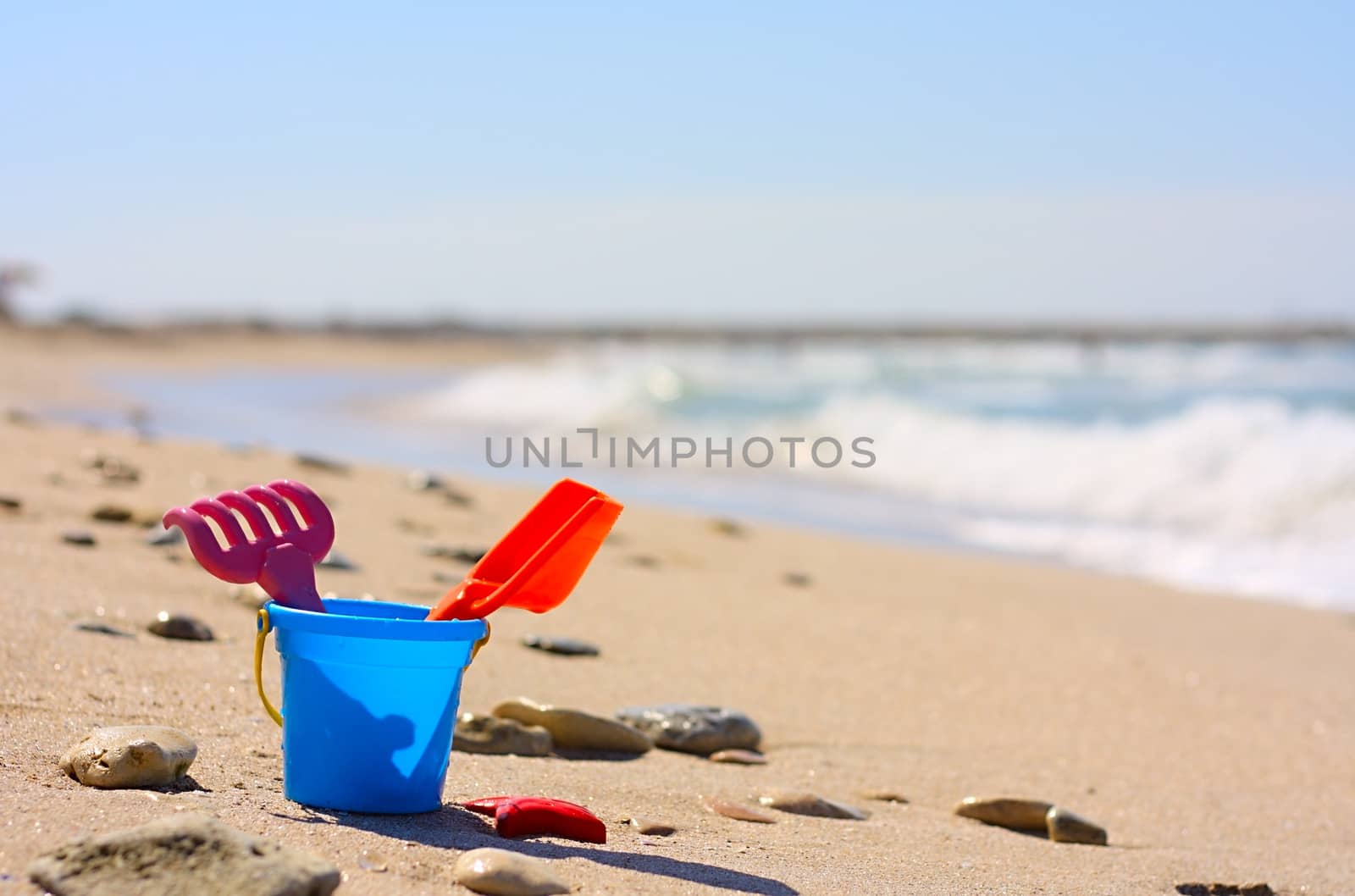 Plastic bucket on the beach by dedmorozz