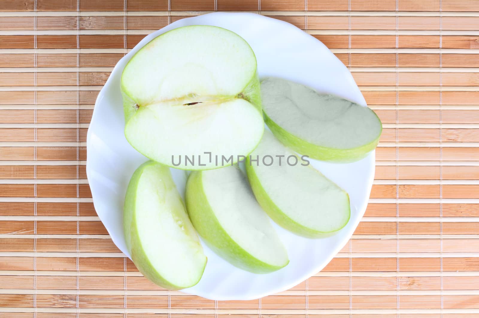 Apple pieces on the plate at the textured background