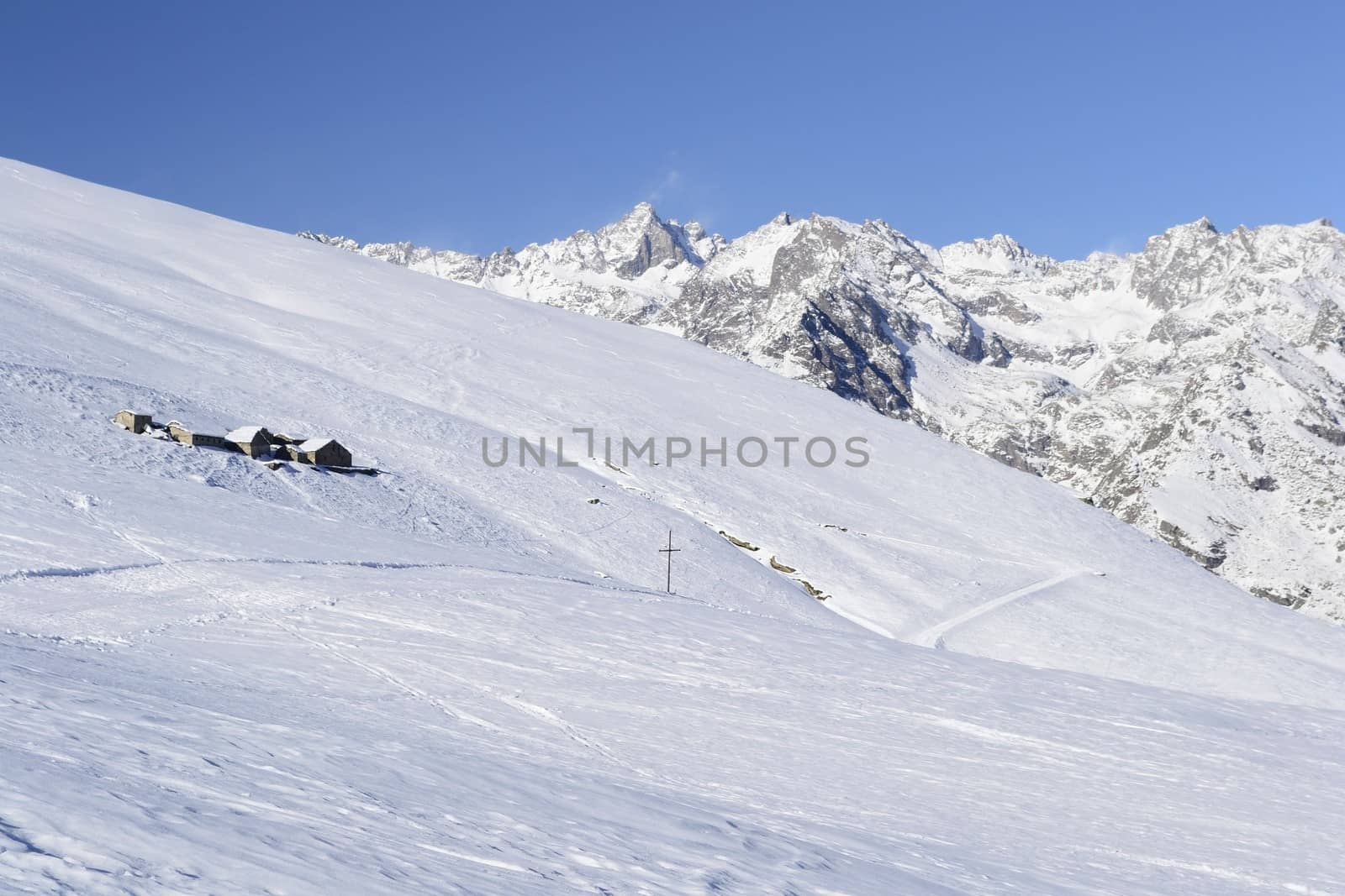 Old pasture huts in scenic winter background by fbxx