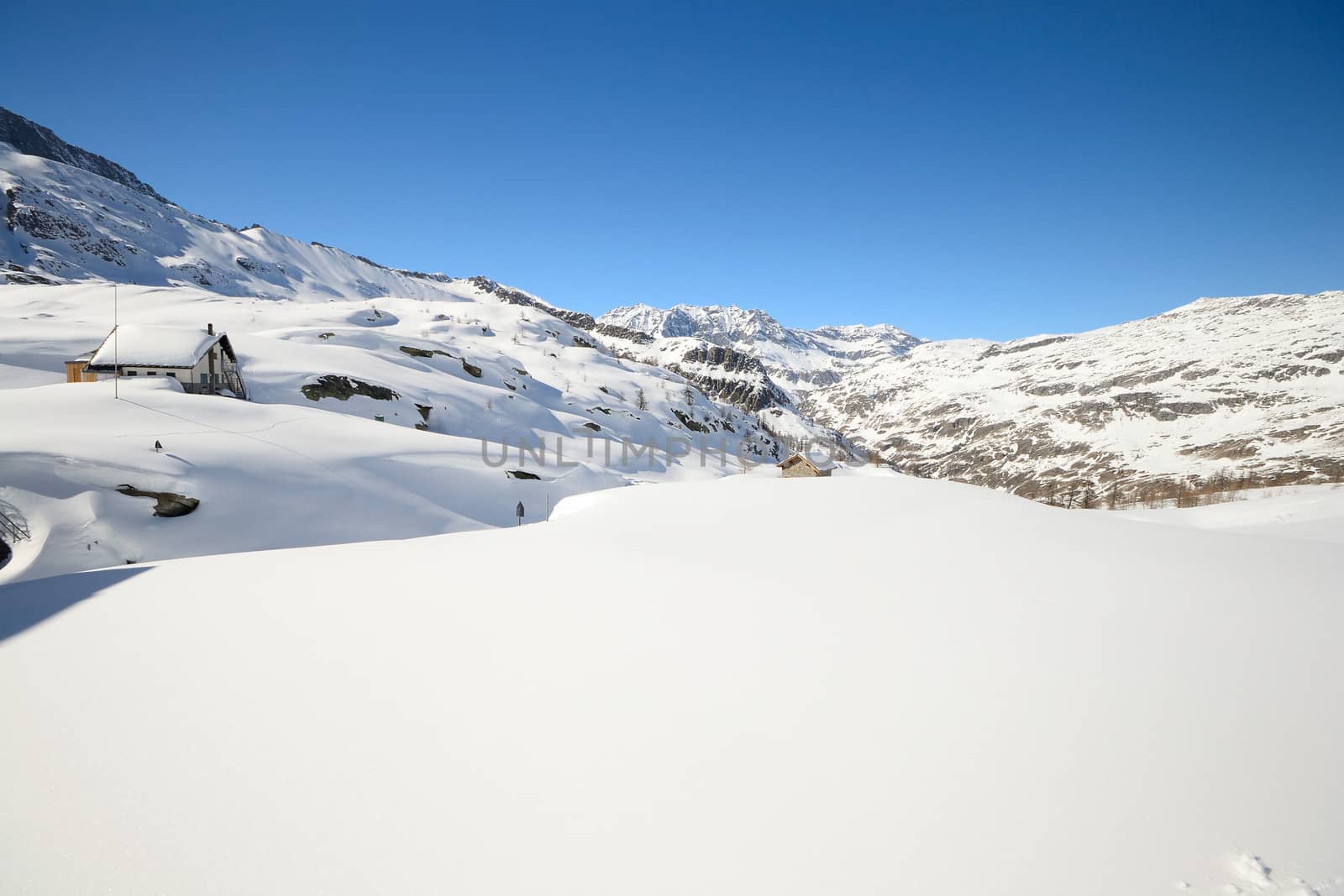 Candid off piste ski slope in scenic background of high mountain peaks, Gran Paradiso National Park, italian Alps