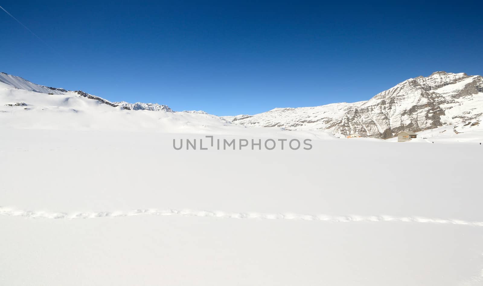 Wildlife traces on a snowy slope in scenic high mountain view, Gran Paradiso National Park, italian Alps