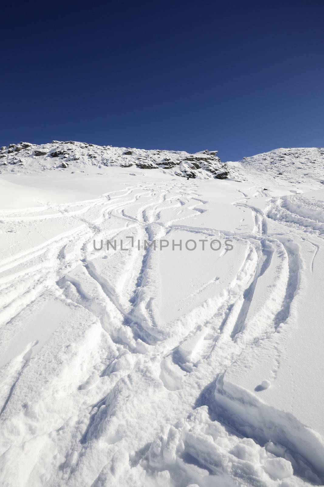 Tour ski tracks on snowy slope in winter scenic landscape