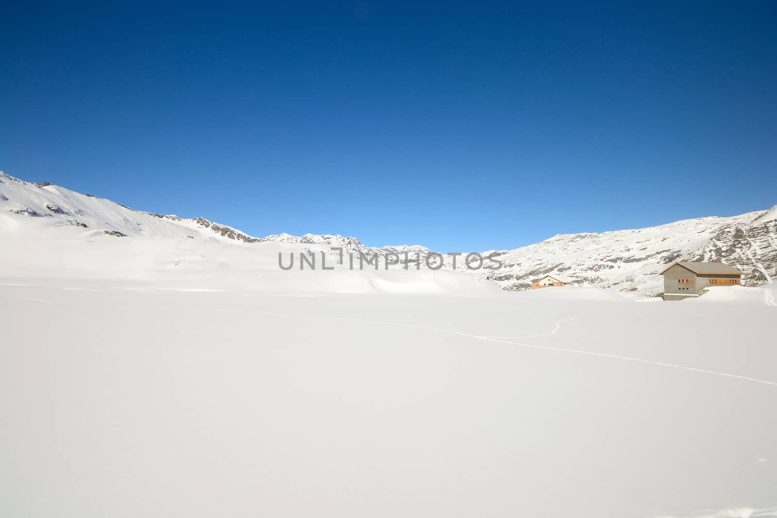 Candid off piste ski slope in scenic background of high mountain peaks, Gran Paradiso National Park, italian Alps