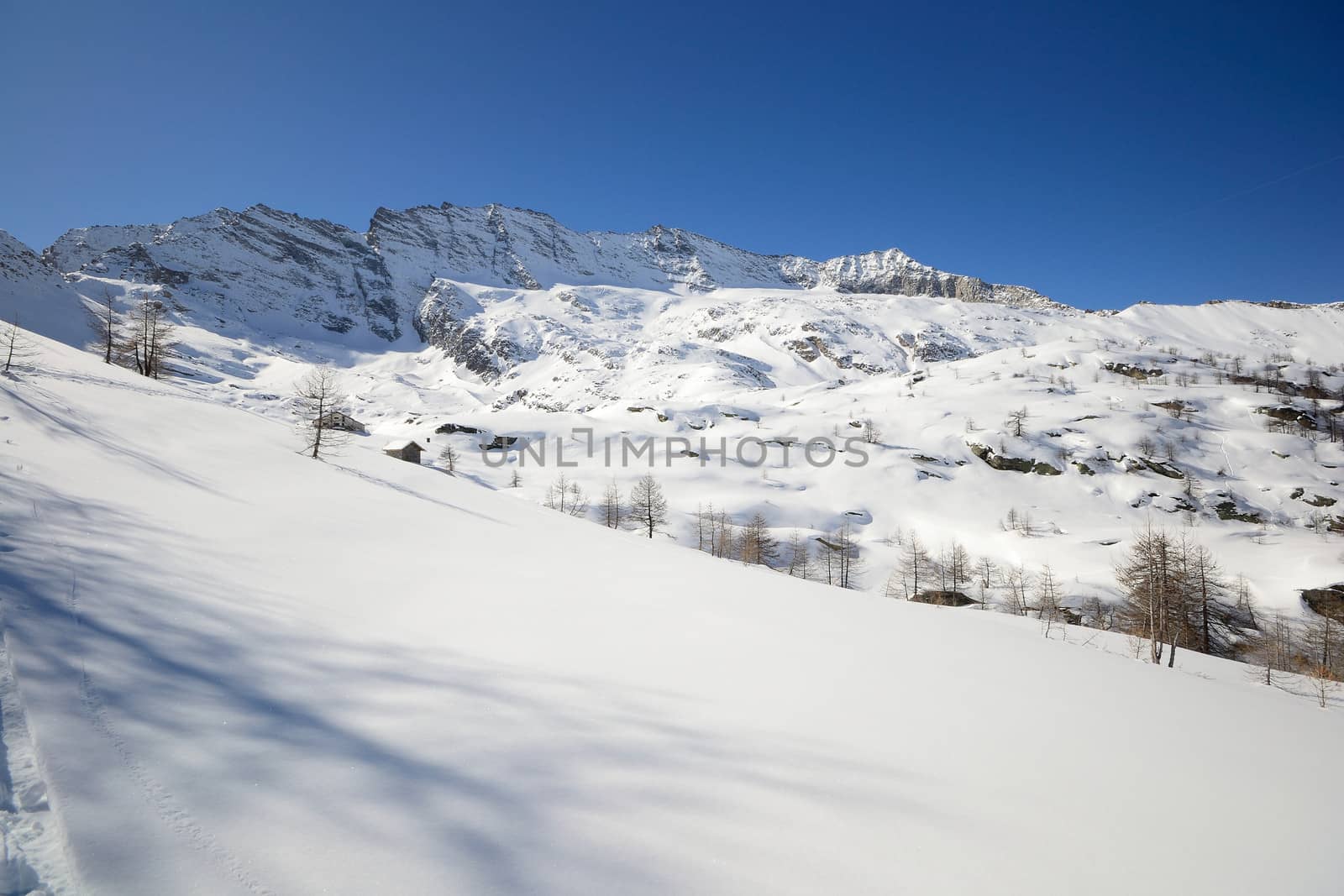 Candid off piste ski slope in scenic background of high mountain peaks, Gran Paradiso National Park, italian Alps