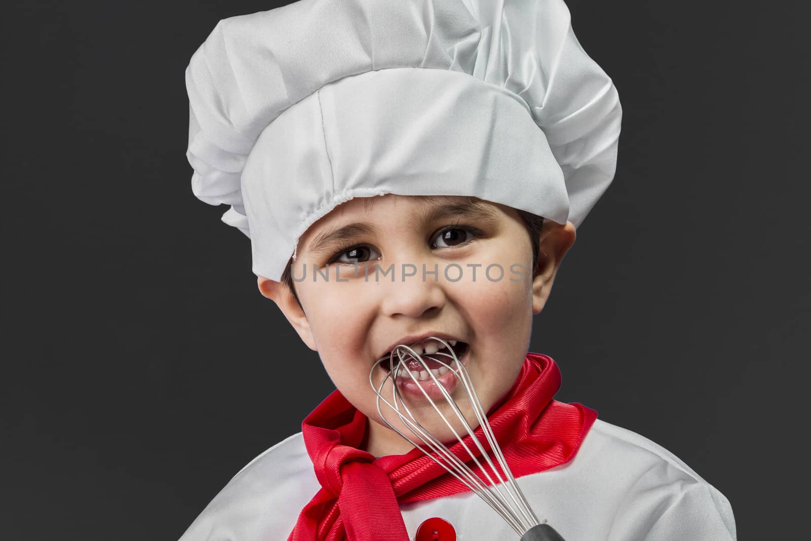 Childhood, Little boy preparing healthy food on kitchen over grey background, cook hat