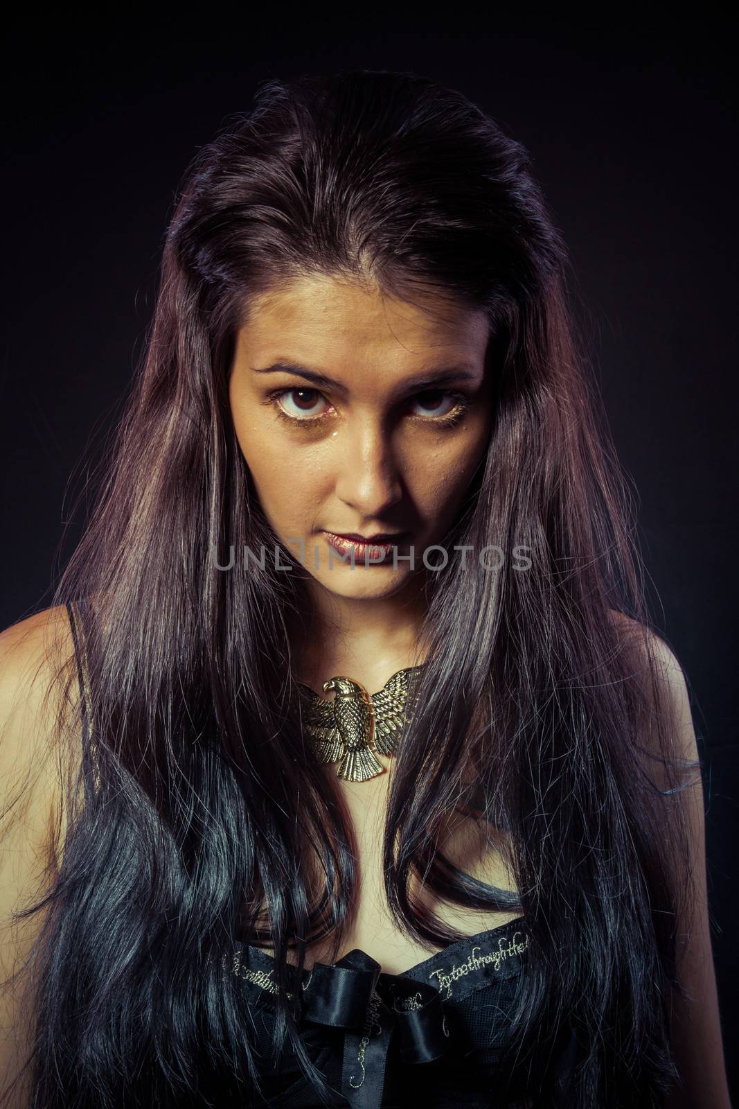 Model, Warrior woman with gold mask, long hair brunette. Long hair. Profile. Studio shot