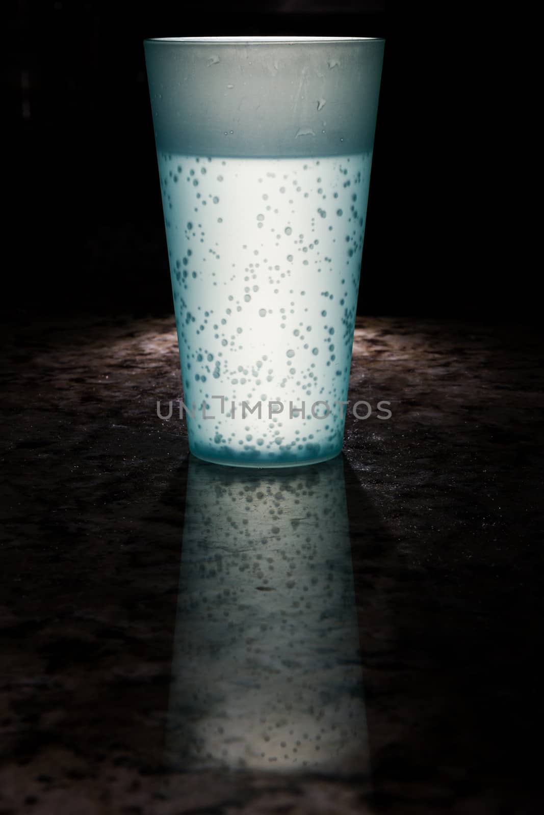 Bright lit cup lit up with a reflection of the cup on marble