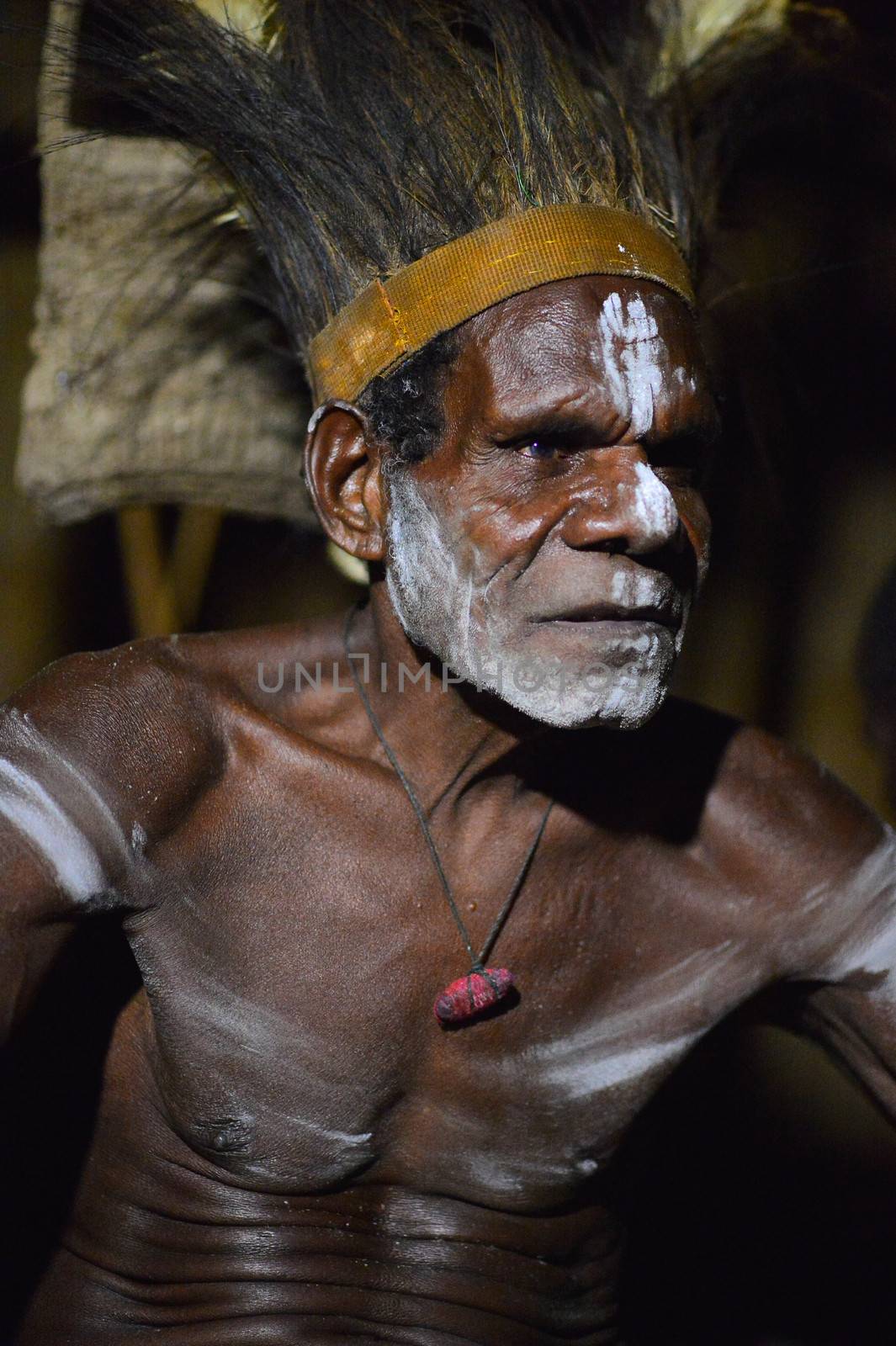 The Portrait Asmat warrior with a traditional painting and coloring on a face. by SURZ