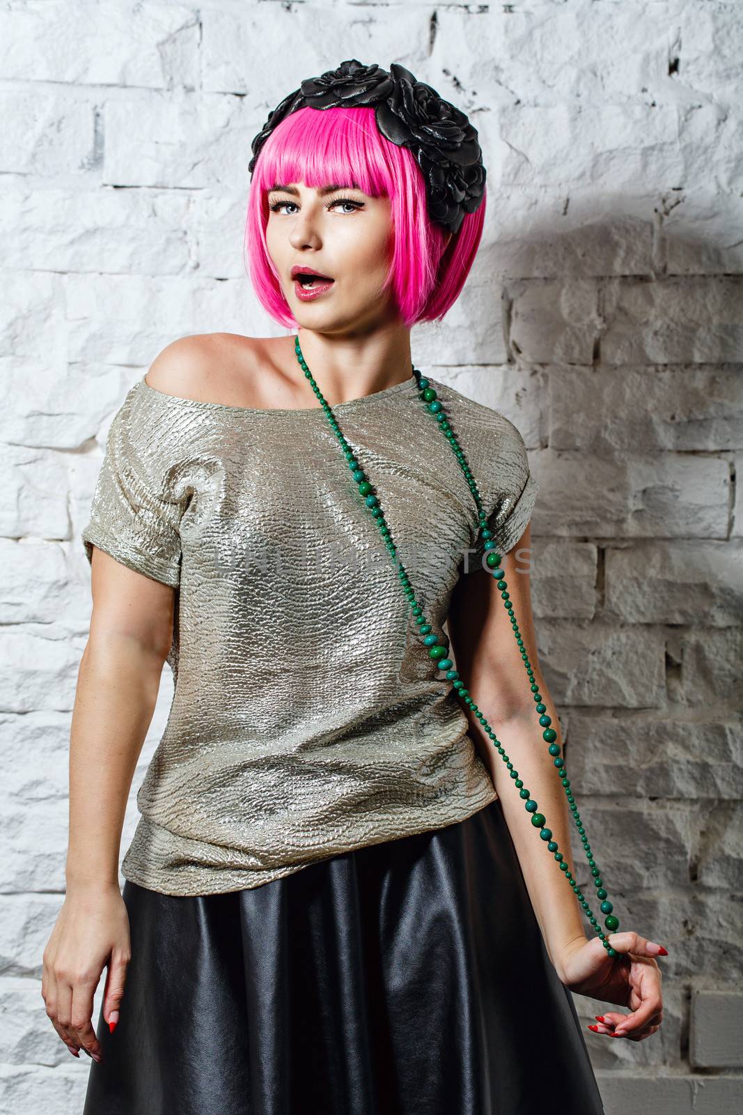 Attractive young girl with rim on head holding beads