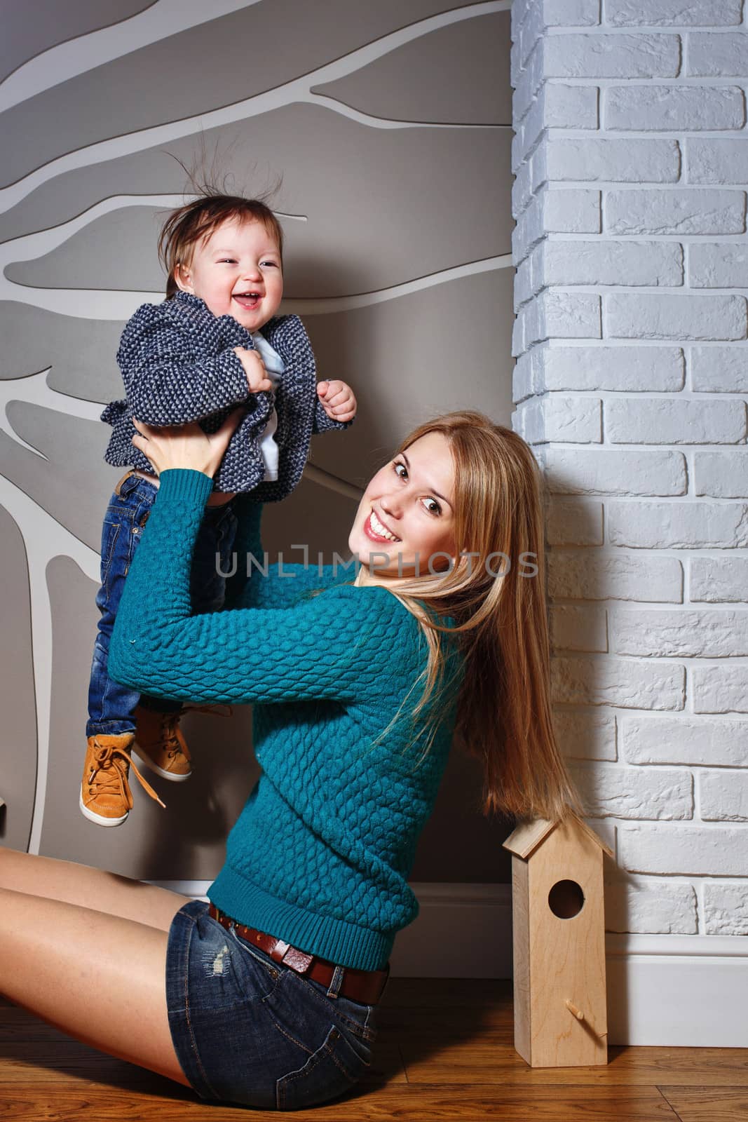 Attractive young blond mother holding her baby in her arms