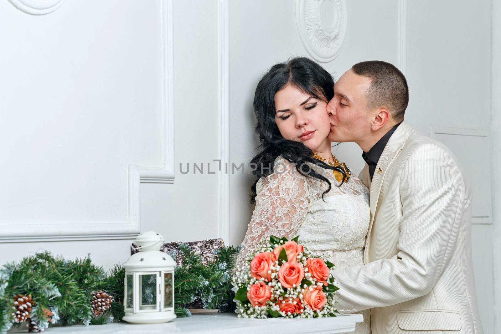 Passionate kiss of young couple near bouquet of roses