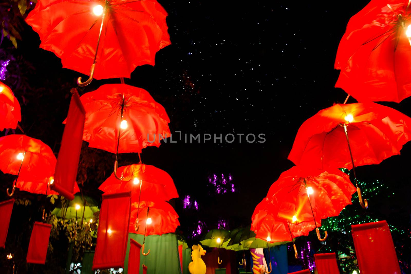 Red umbrella in the night sky with colorful light