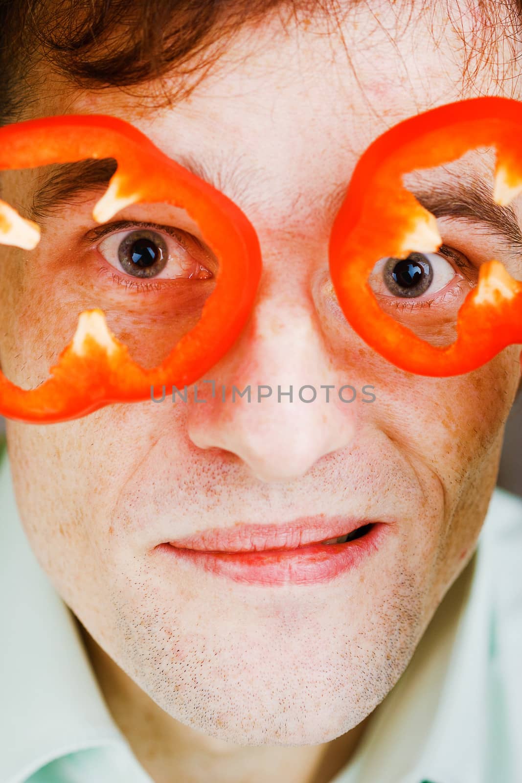 Young man with red pepper. Face close-up. humor