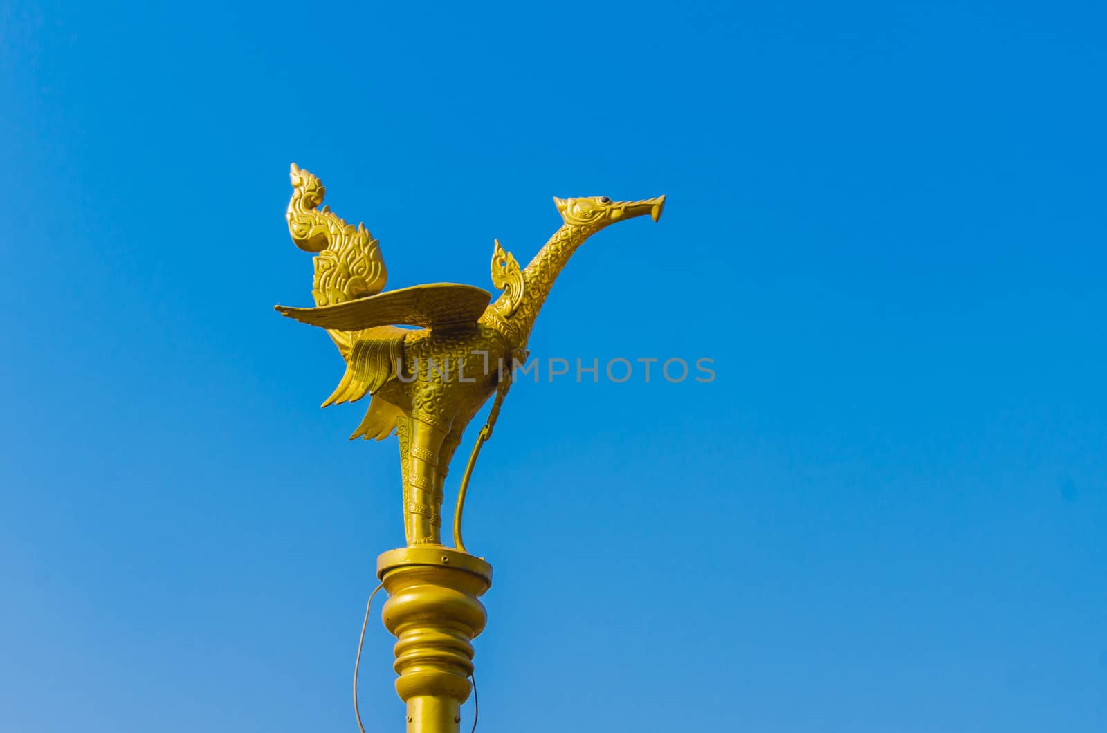 Gold swan sculpture on blue sky