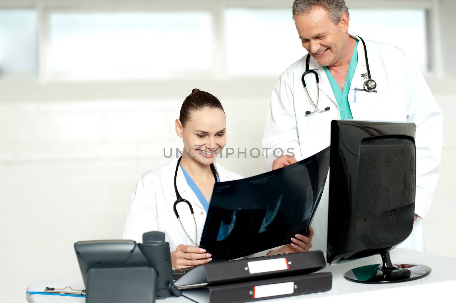 Physicians reviewing patients x-ray report by stockyimages