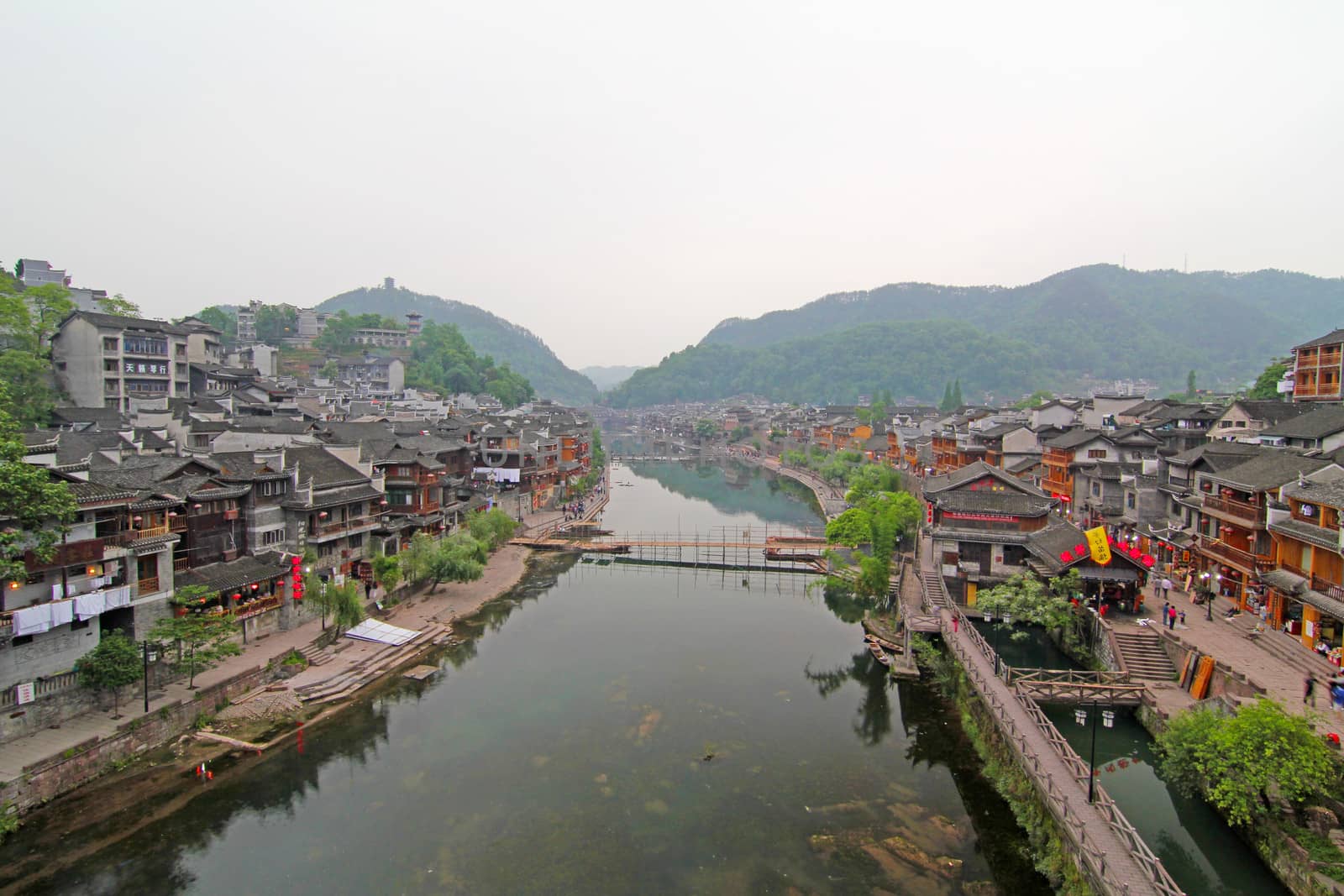 FENGHUANG - MAY 12: Wooden boat and wooden houses at tuojiang river in fenghuang ancient town on May 12, 2011 in Fenghuang, China.