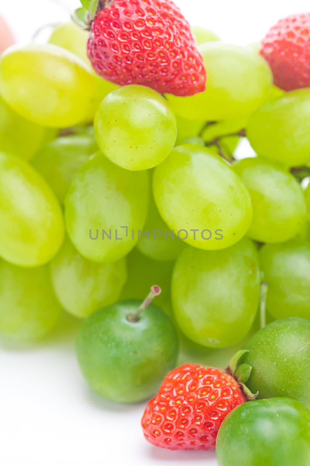 bunch of white grapes and strawberries isolated on white by jannyjus