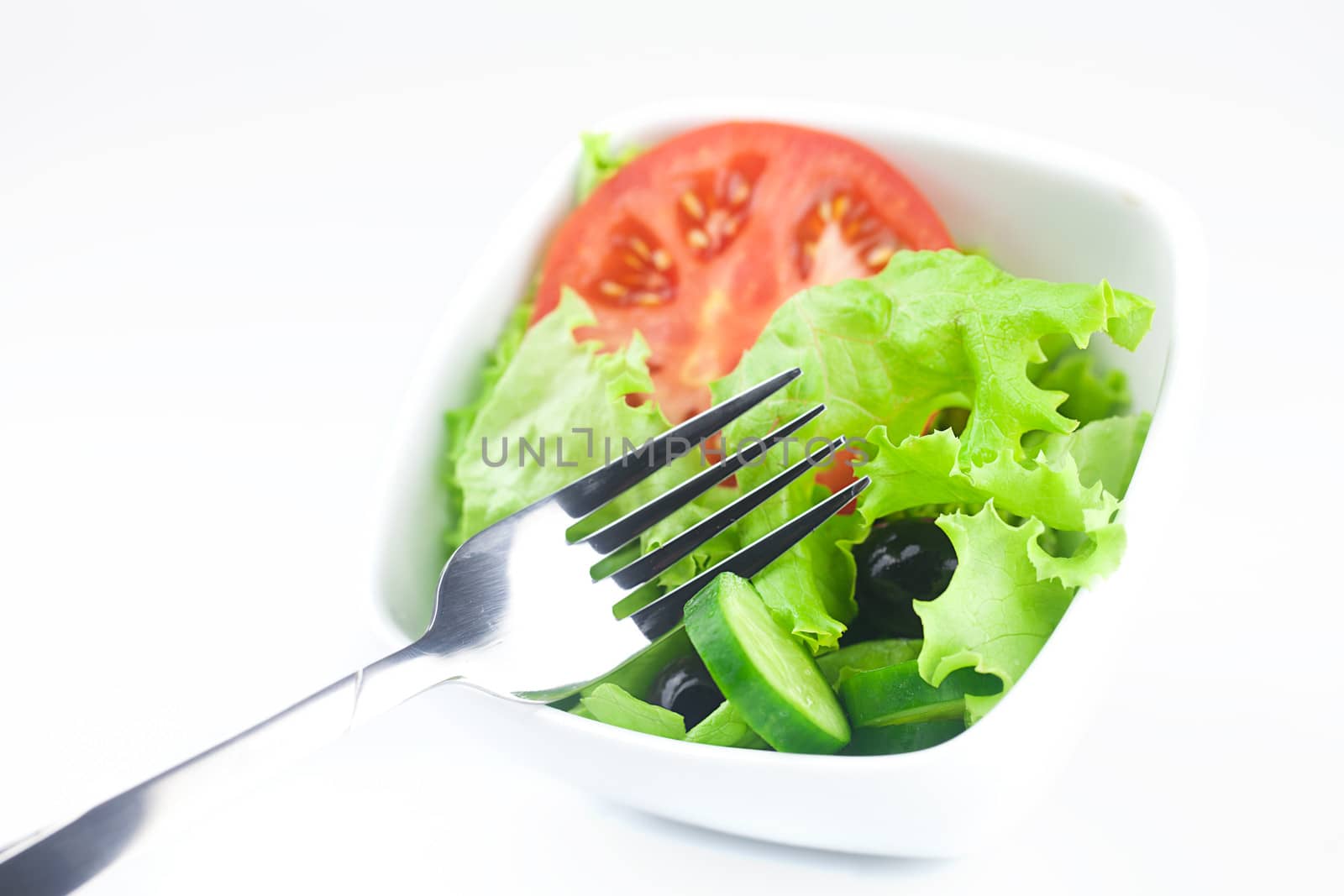 fork,black olive,lettuce, tomato, cucumber and pepper in a bowl by jannyjus